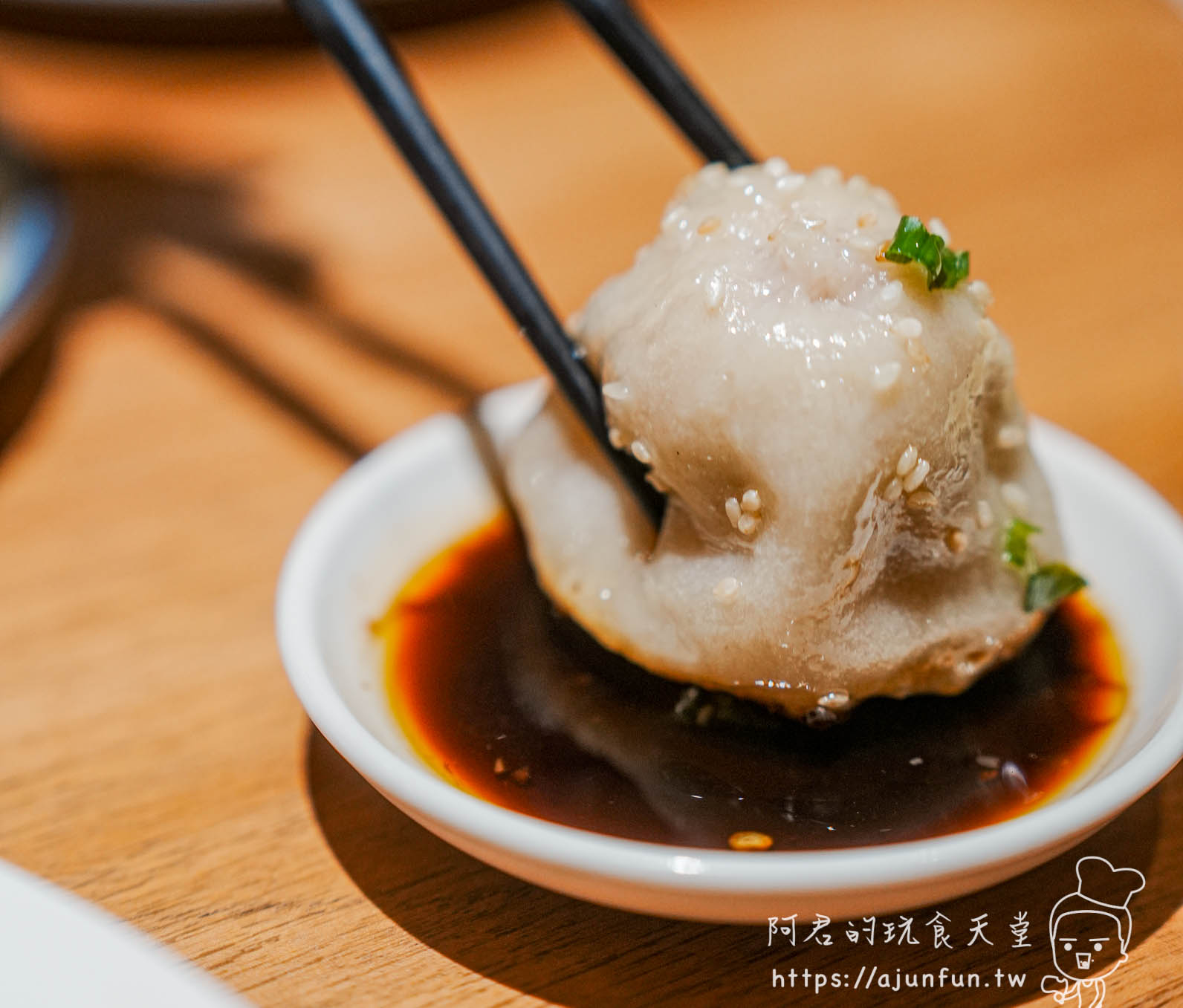 滬舍餘味西屯店招牌綜合生煎包-筷子夾起鮮肉生煎沾鎮江醋小碟