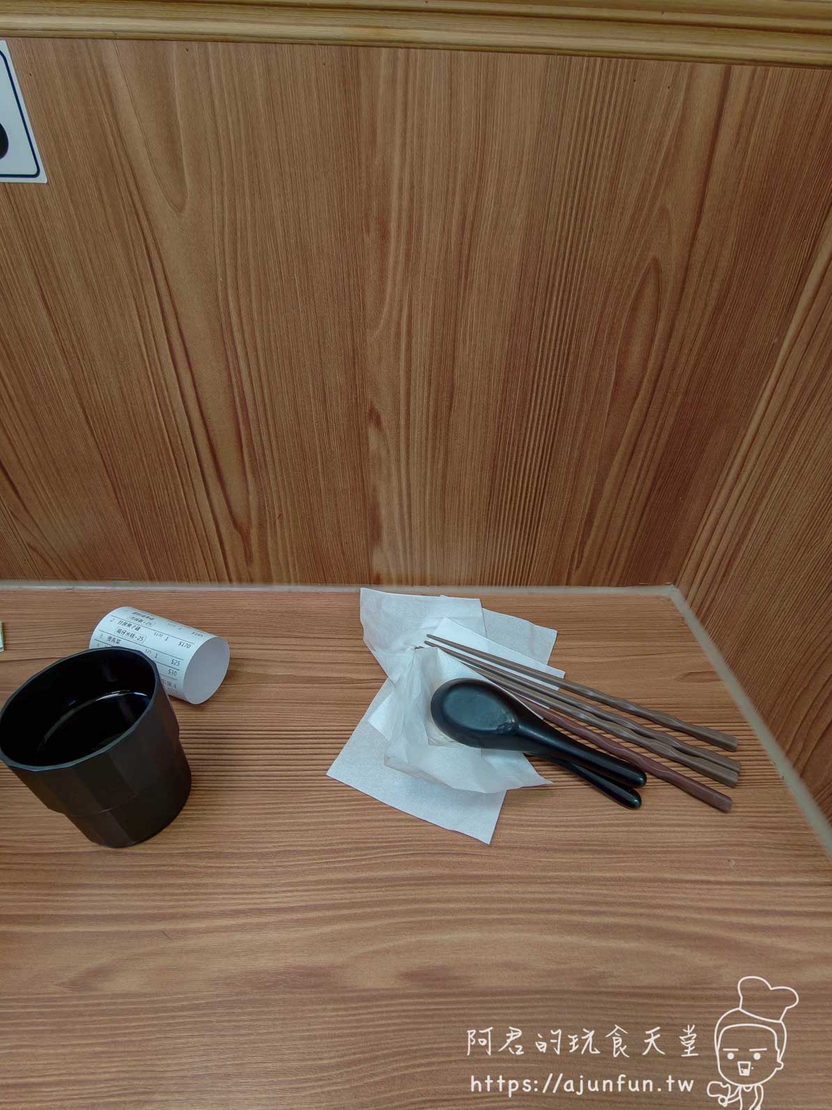 盛盅燉湯木桌上的水杯、點餐單與包好的餐具