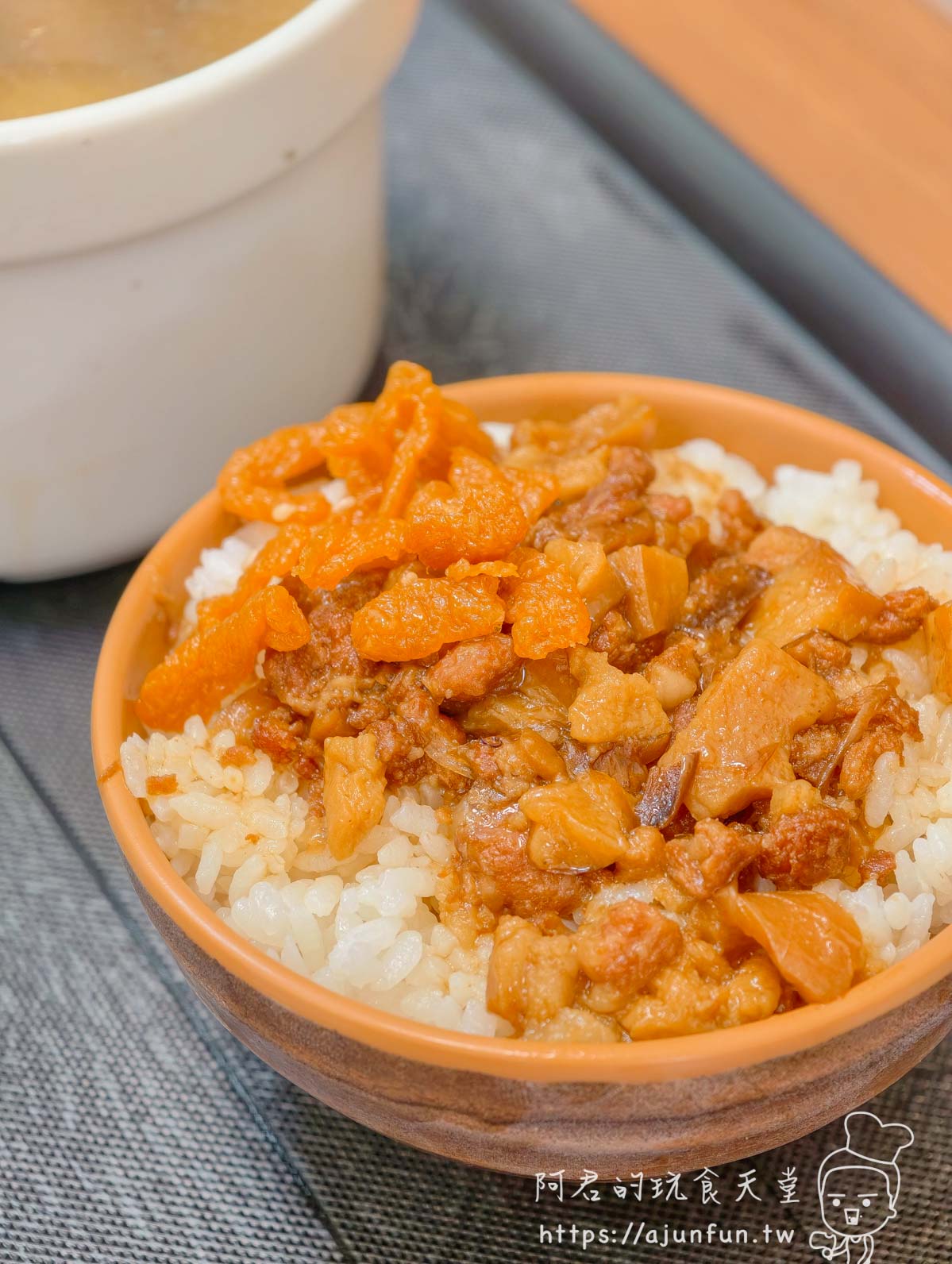 橘色木碗盛著肉燥飯，肉燥油亮淋在白飯上