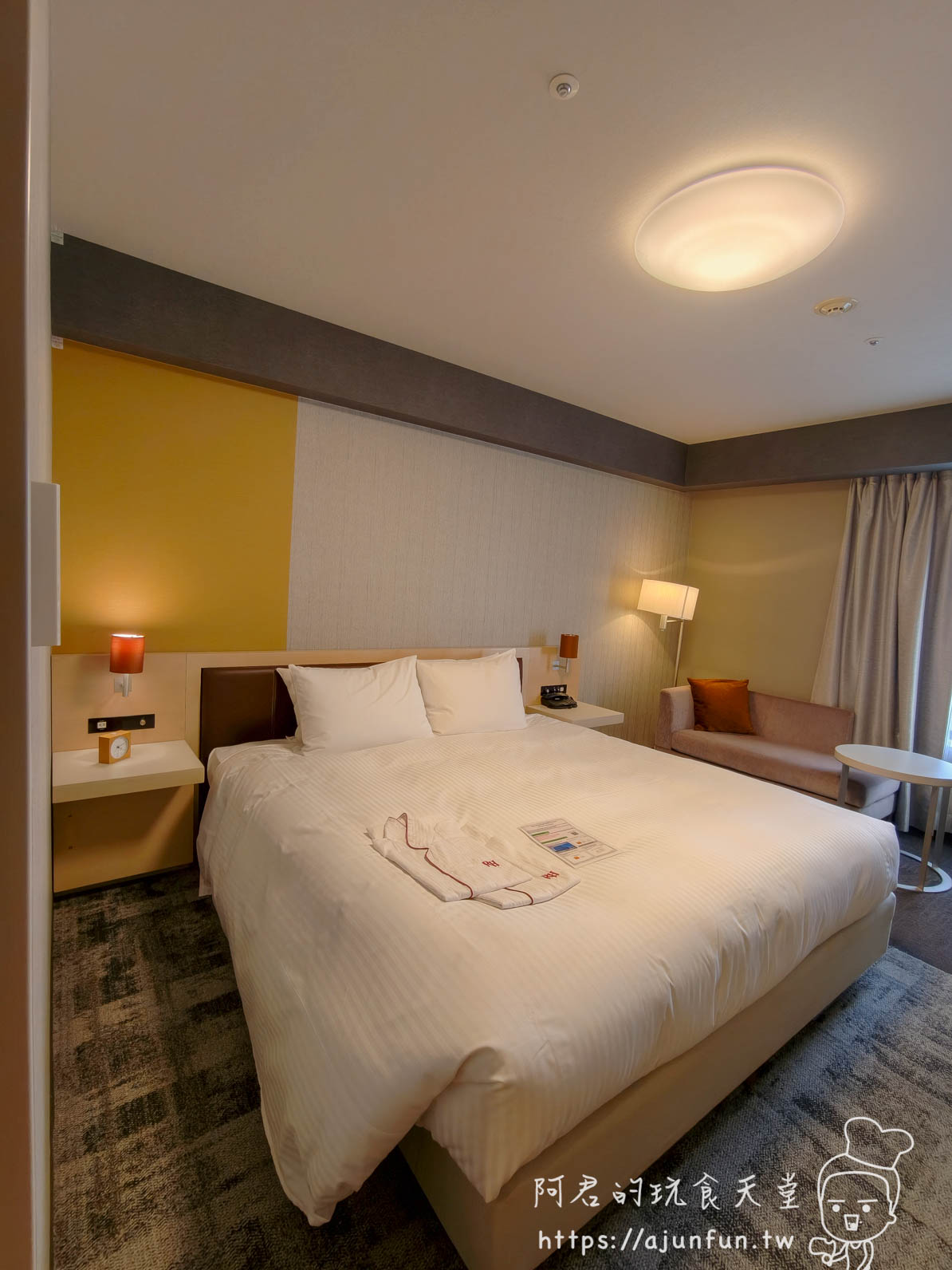 成田 Richmond Hotel 雙人房床鋪正面寬景，橘色床頭板與兩盞床頭夜燈