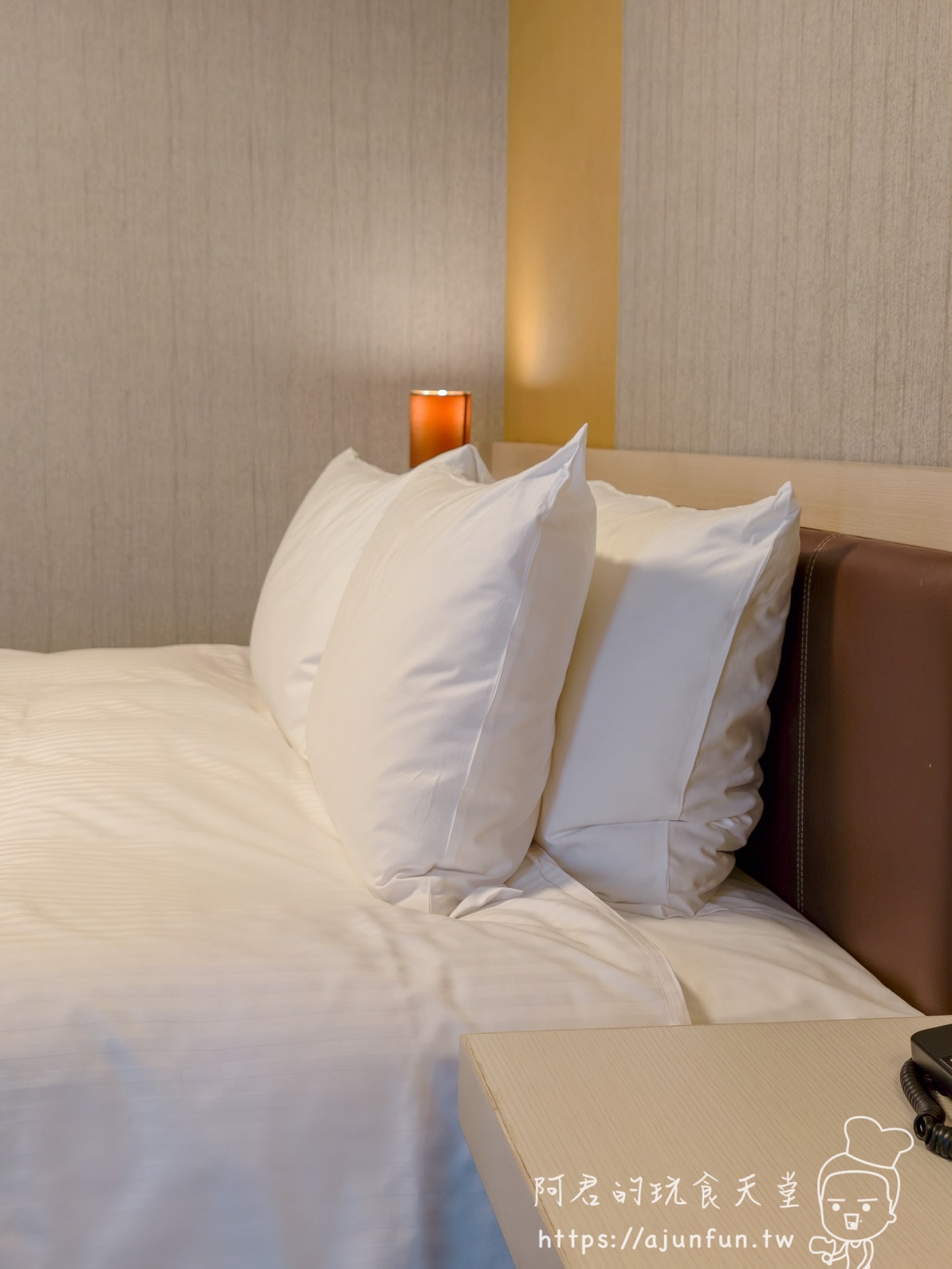 成田 Richmond Hotel 雙人房床鋪枕頭近景，兩顆白色枕頭與橘色床頭夜燈
