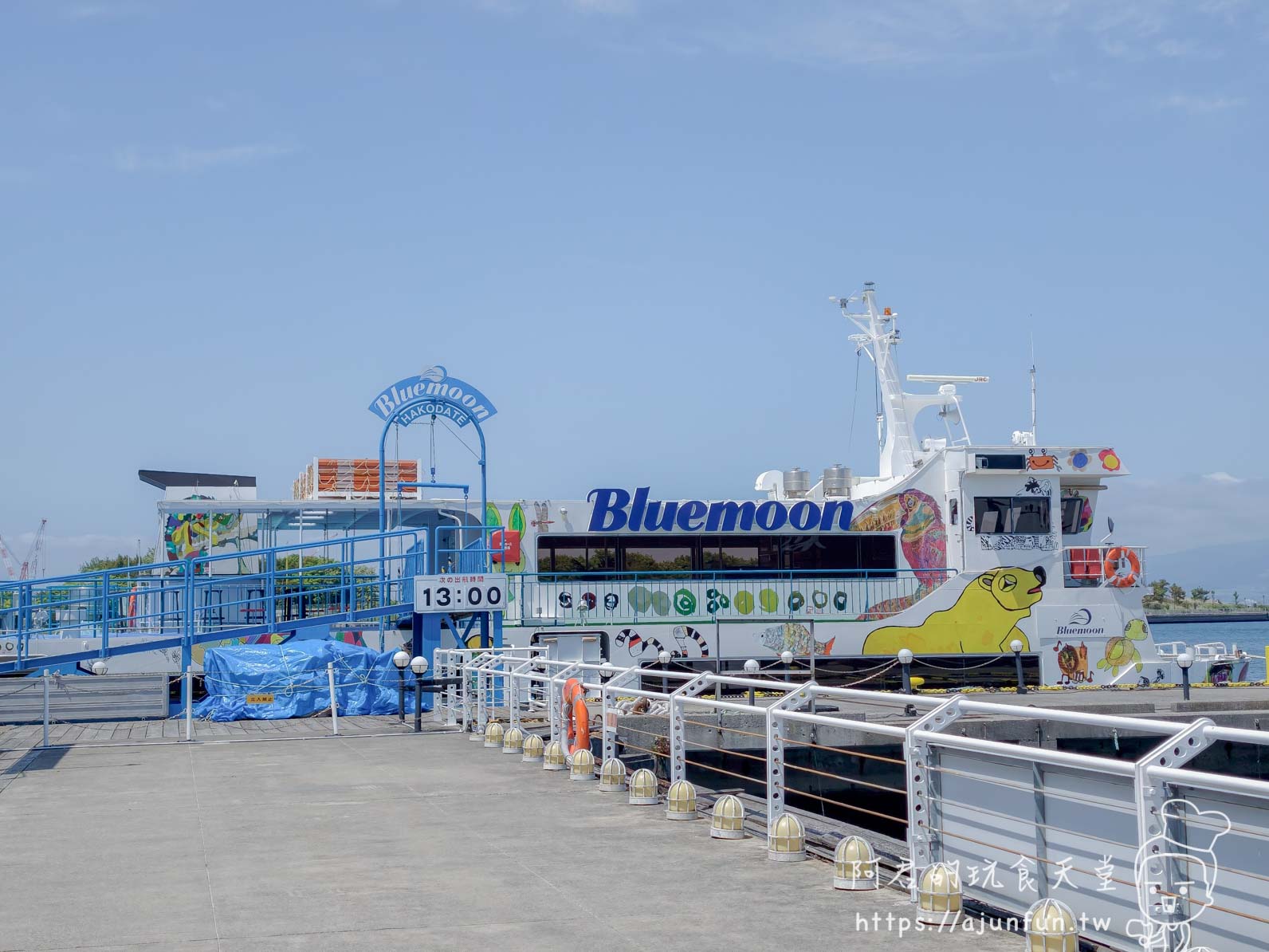 【函館景點】 Bluemoon 港內遊覽船攻略 2026|怎麼搭、票價多少、坐哪個位子才划算 - 第2張圖 Bluemoon 遊覽船船身正面 藍色大字船名 HAKODATE 拱門入口 黃色海豹海龜彩繪 - 阿君的玩食天堂