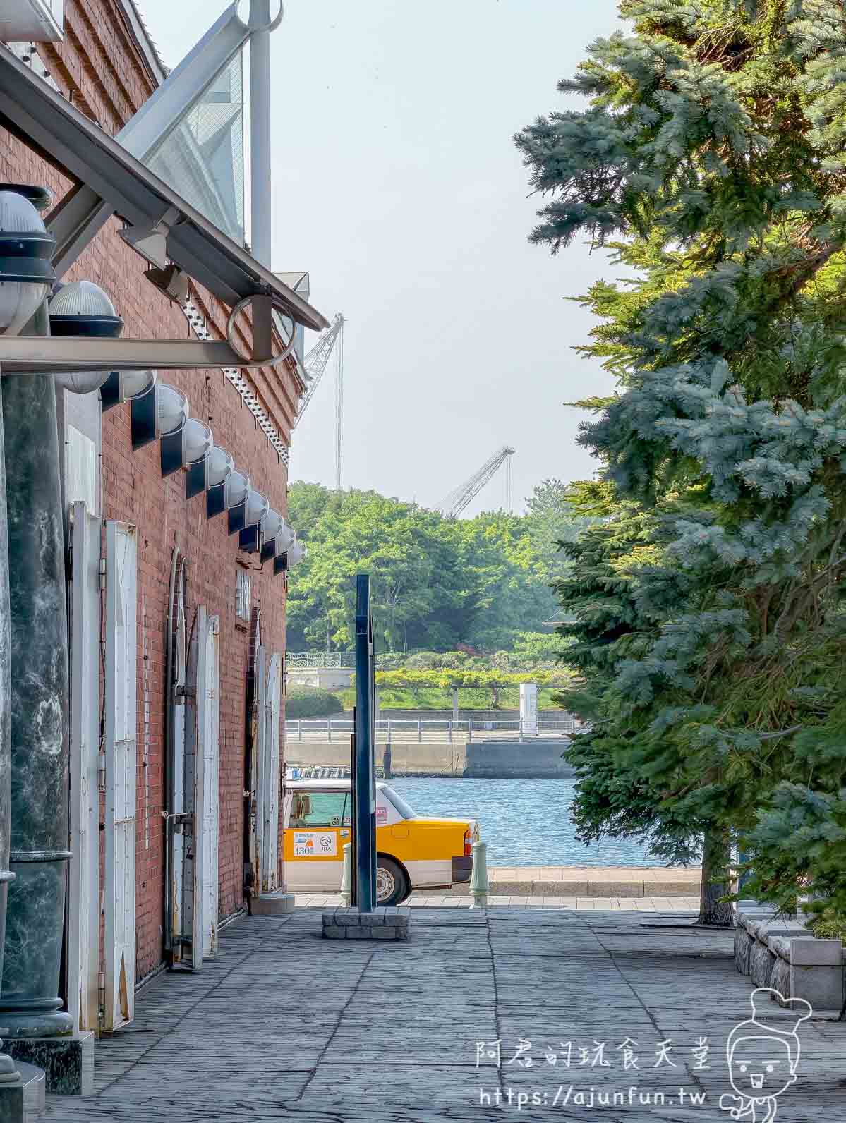 金森紅磚倉庫側廊窄走道透出港灣水面黃色計程車停靠遠景