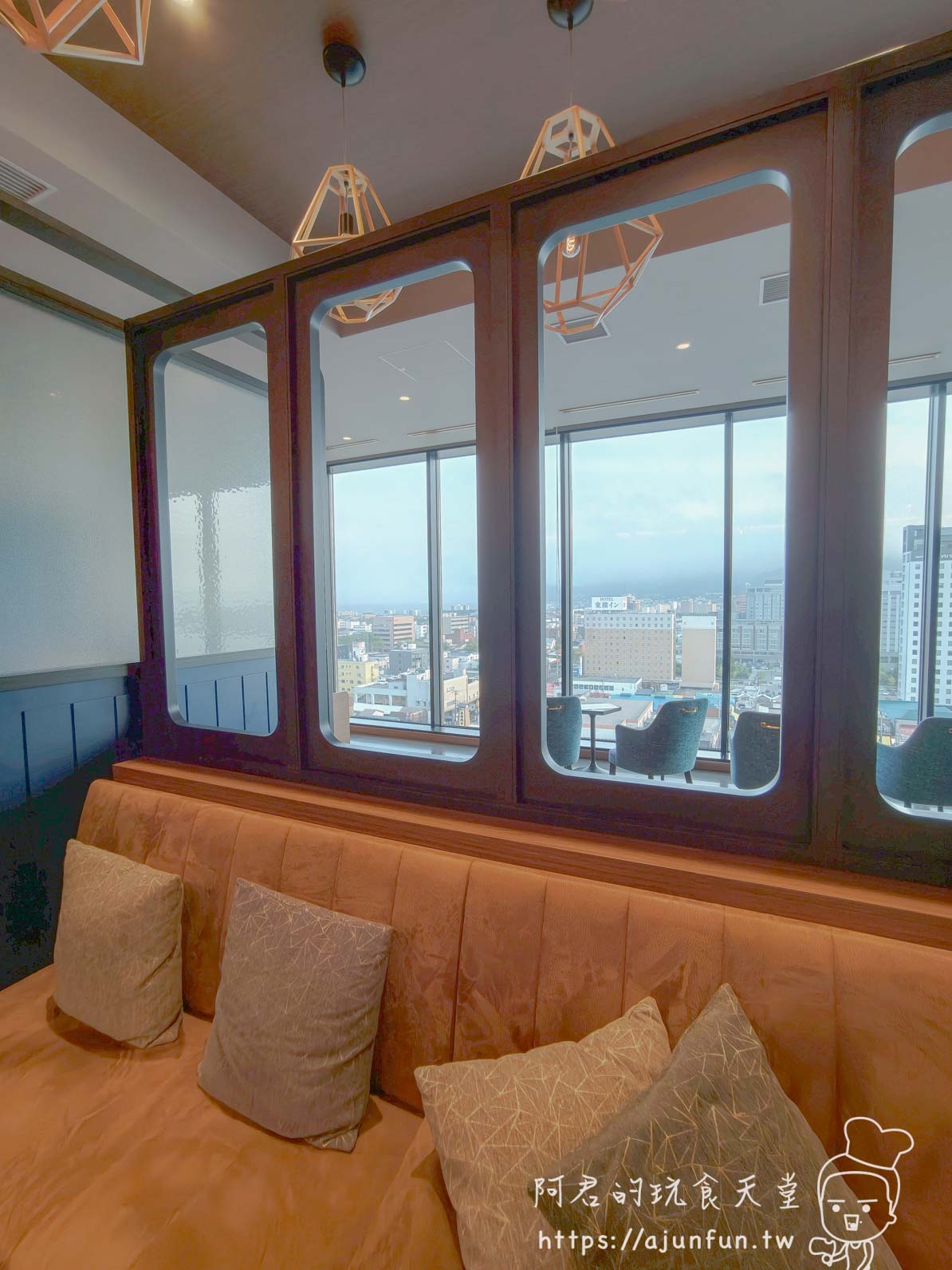 JR INN 函館 高樓層公共休憩空間，圓弧木框窗牆與絨布長椅可俯瞰函館市區街景 - 阿君的玩食天堂