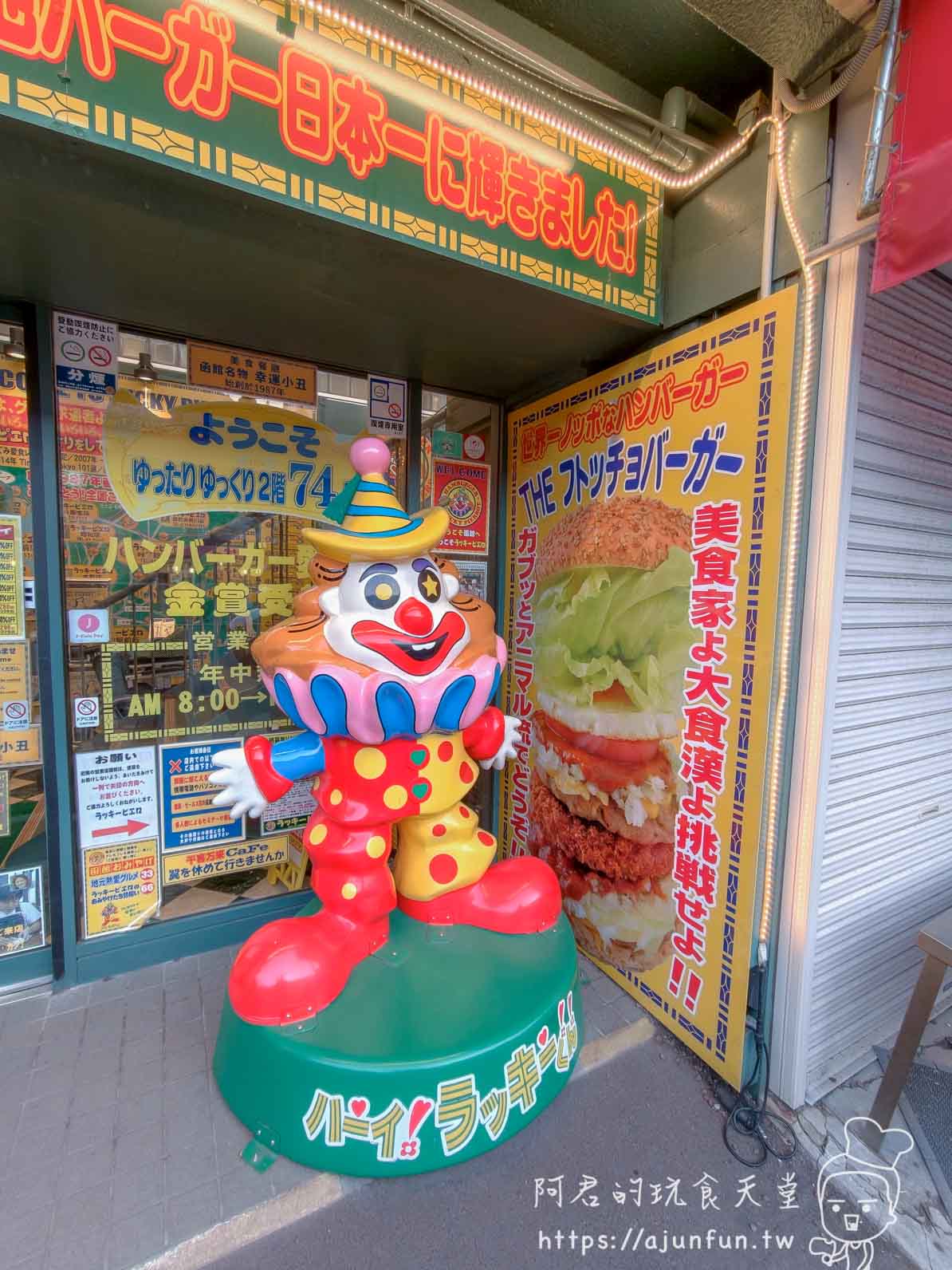 【函館必吃】幸運小丑漢堡 函館駅前店|中華炸雞堡必點、價格菜單與排隊攻略2026 - 第7張圖 ラッキーピエロ 函館駅前店 入口小丑塑像與THE フトッチョバーガー廣告立牌 - 阿君的玩食天堂