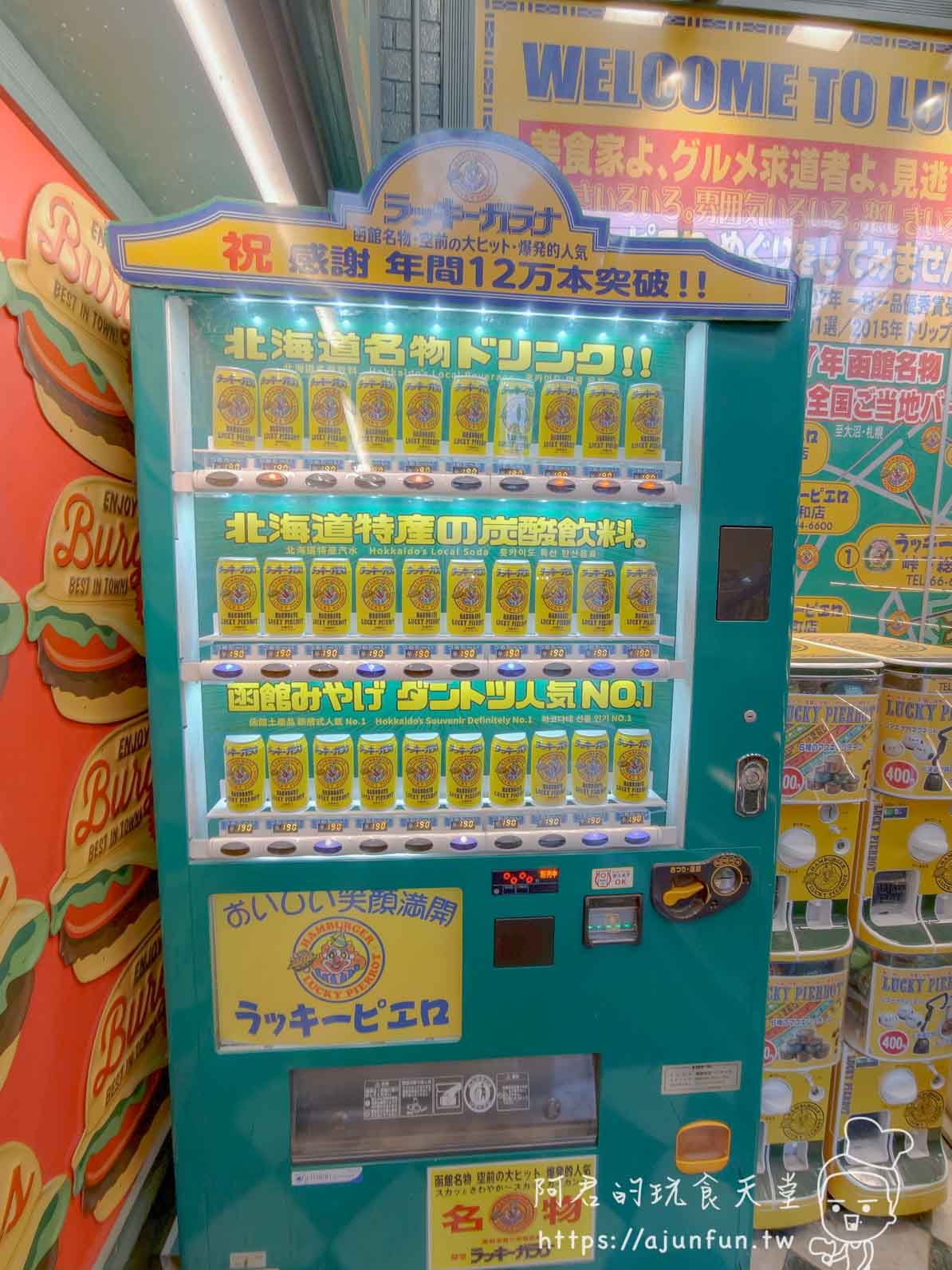 【函館必吃】幸運小丑漢堡 函館駅前店|中華炸雞堡必點、價格菜單與排隊攻略2026 - 第6張圖 ラッキーピエロ 函館駅前店 ラッキーカラナ青綠色自動販賣機整牆黃罐 - 阿君的玩食天堂