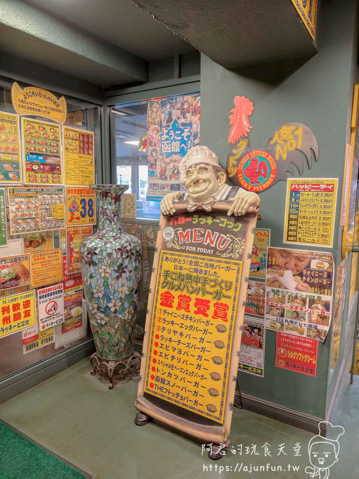 【函館必吃】幸運小丑漢堡 函館駅前店|中華炸雞堡必點、價格菜單與排隊攻略2026 - 第9張圖 ラッキーピエロ 函館駅前店 2F入口廚師立牌金賞漢堡獲獎品項清單 - 阿君的玩食天堂