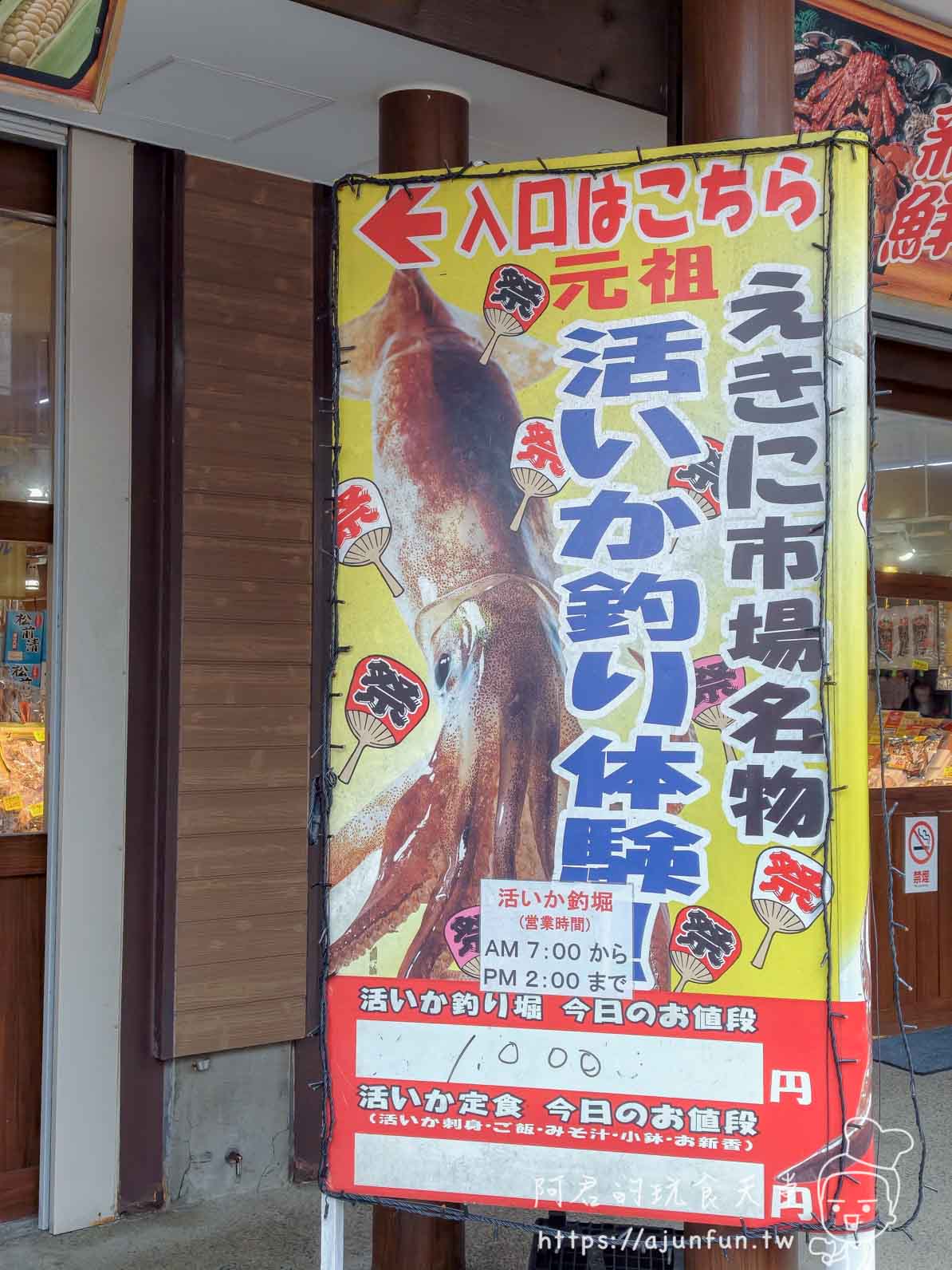 【函館朝市美食】元祖活烏賊釣堀|現釣現切刺身體驗(2026) - 第2張圖 元祖活烏賊釣堀 駅二市場外黃底紅字立招牌 1000円 - 阿君的玩食天堂