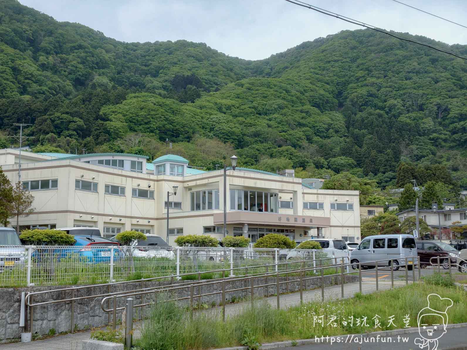 谷地頭溫泉 米黃色建築外觀與綠頂圓塔、後方森林山坡 - 阿君的玩食天堂