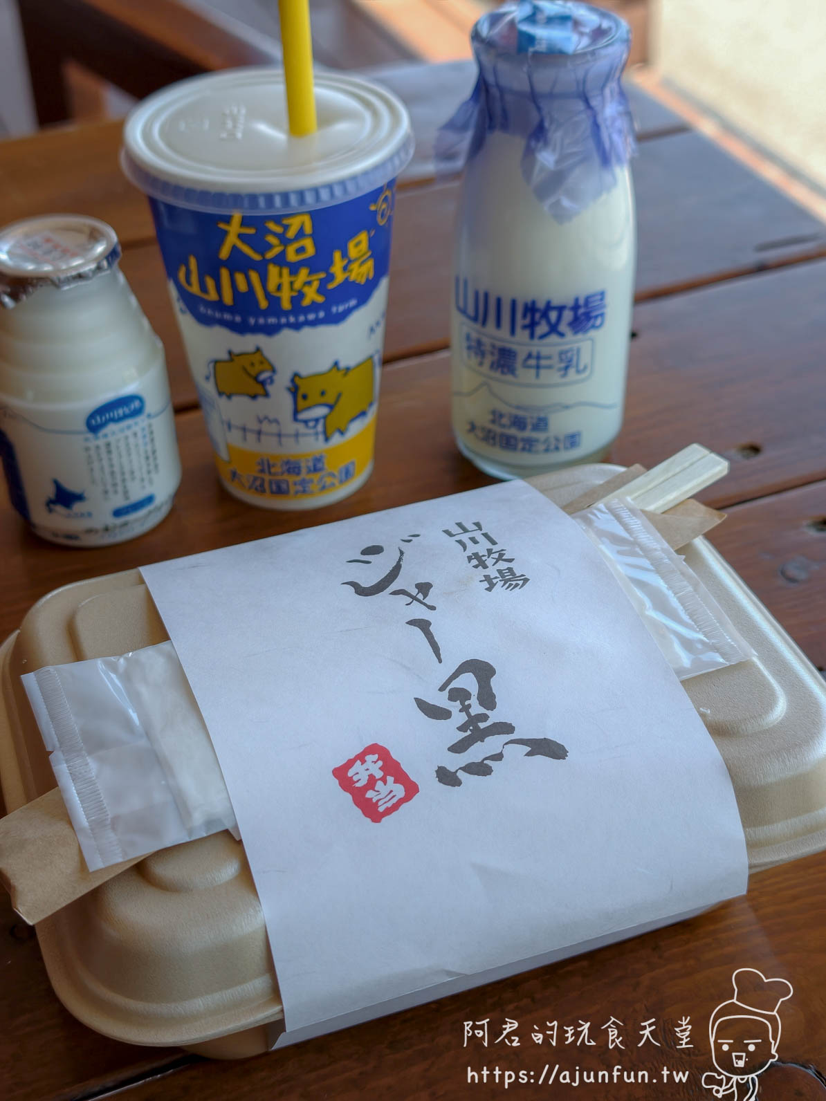 山川牧場（大沼ミルクプラント） 特濃牛乳玻璃瓶、大沼牧場杯裝飲品與ジャージー金乳套餐擺在木桌上 - 阿君的玩食天堂