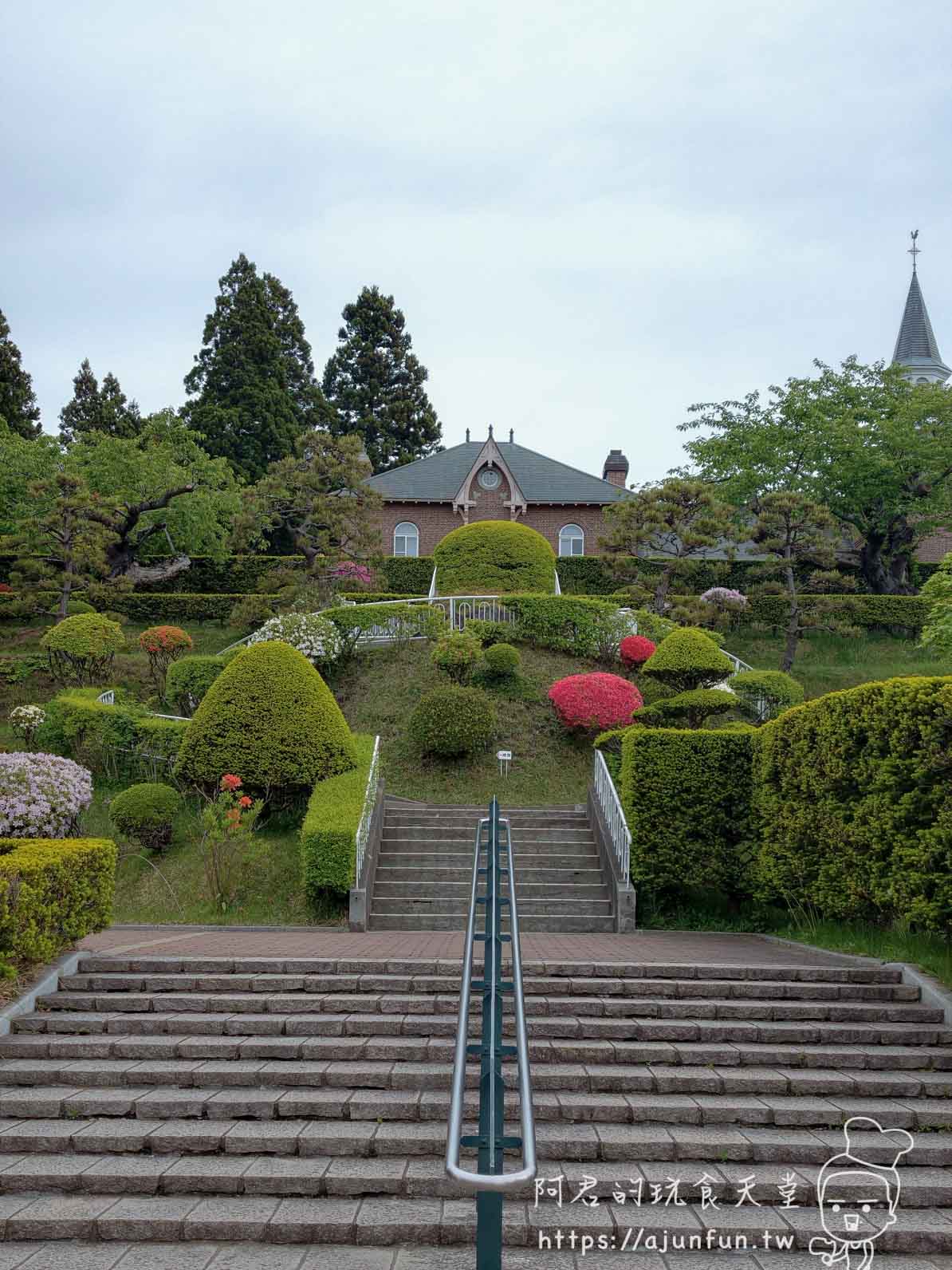 【函館景點】特拉普女子修道院攻略|免費門票、交通、開放時間與停車資訊 - 第14張圖 トラピスチヌ修道院 石階仰拍紅磚主樓與白色尖塔全景 - 阿君的玩食天堂